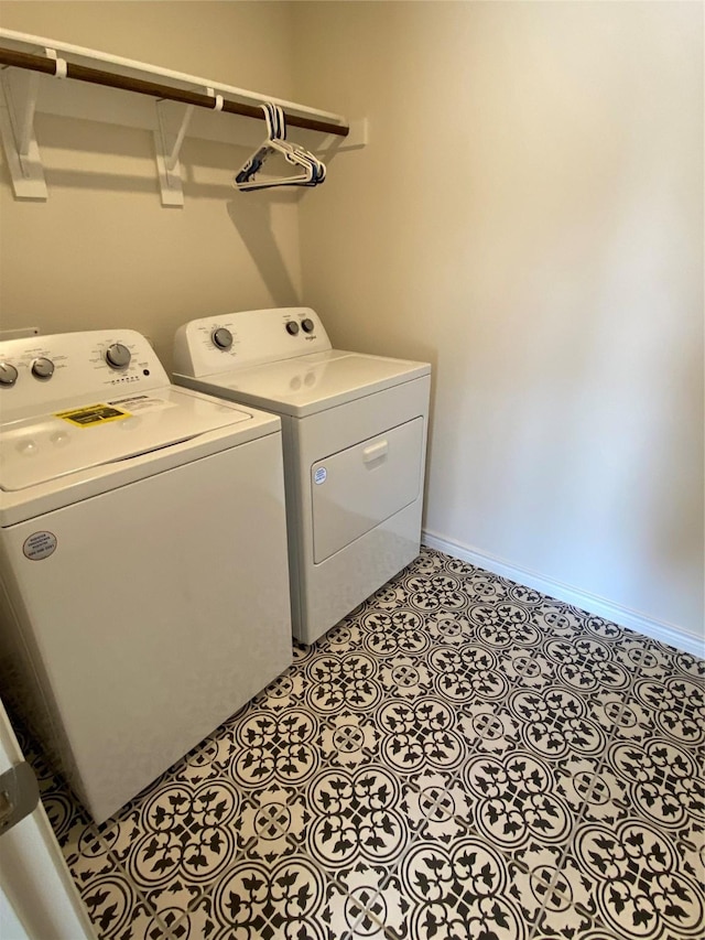 washroom featuring washer and dryer, baseboards, laundry area, and light floors