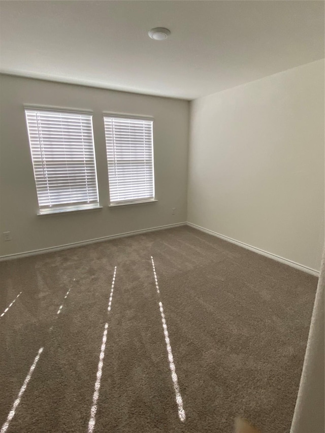 spare room featuring baseboards and carpet floors