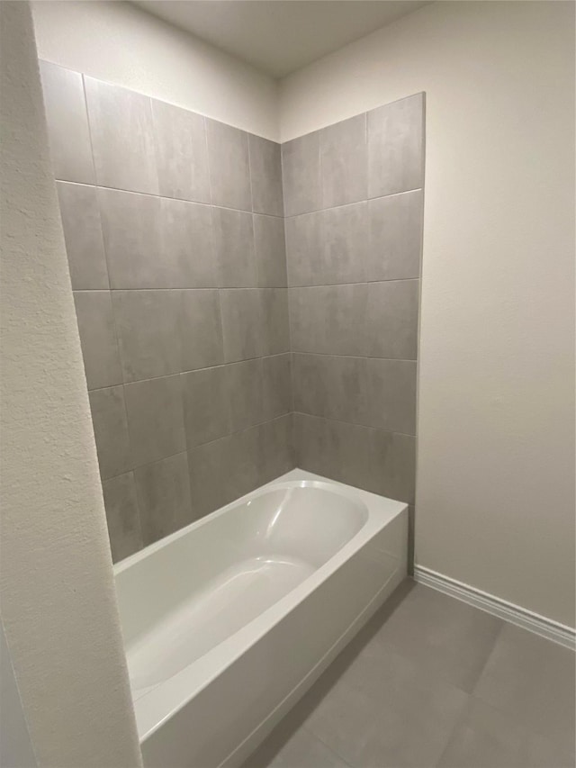 bathroom with baseboards and a bathtub