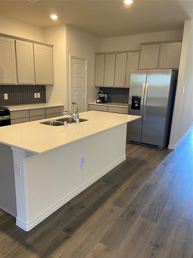 kitchen with a sink, dark wood-style floors, recessed lighting, stainless steel fridge with ice dispenser, and backsplash