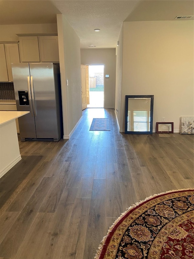 interior space featuring visible vents, dark wood finished floors, and baseboards