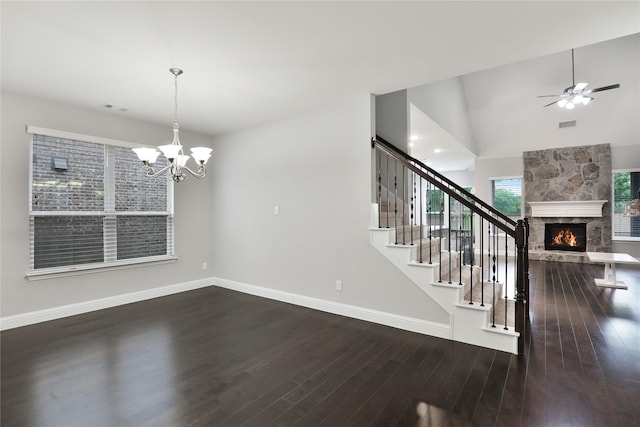 interior space with stairway, baseboards, a fireplace, wood finished floors, and ceiling fan with notable chandelier