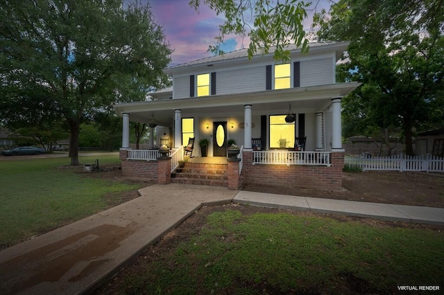 view of front of home featuring fence, covered porch, a yard, and metal roof