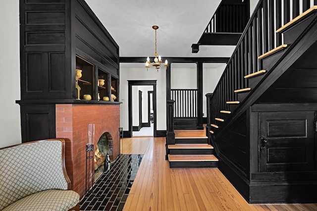 foyer entrance featuring an inviting chandelier, hardwood / wood-style floors, and stairs