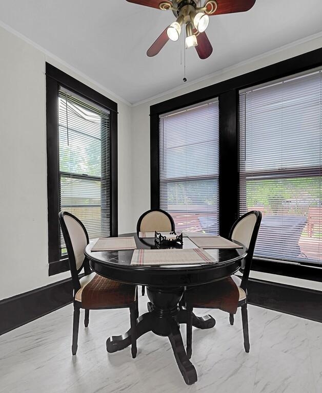 dining room with ornamental molding, a ceiling fan, and plenty of natural light