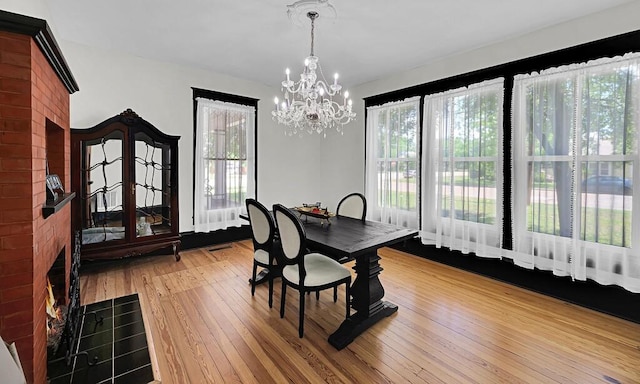 dining space with a chandelier, visible vents, and wood-type flooring