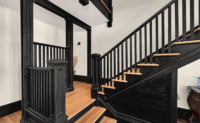 stairway with baseboards and wood finished floors