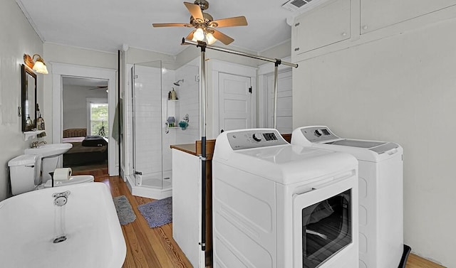 laundry room with ornamental molding, a ceiling fan, light wood finished floors, and washing machine and dryer