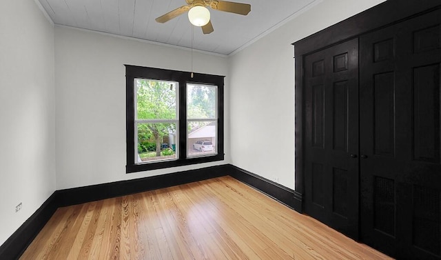 spare room with ornamental molding, ceiling fan, wood finished floors, and baseboards