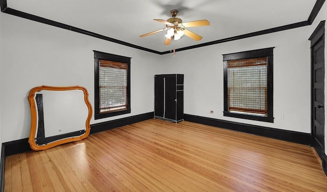 unfurnished room featuring baseboards, ornamental molding, a ceiling fan, and wood finished floors