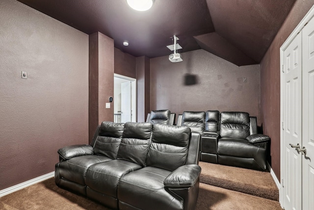 home theater room with lofted ceiling, a textured wall, carpet flooring, and baseboards