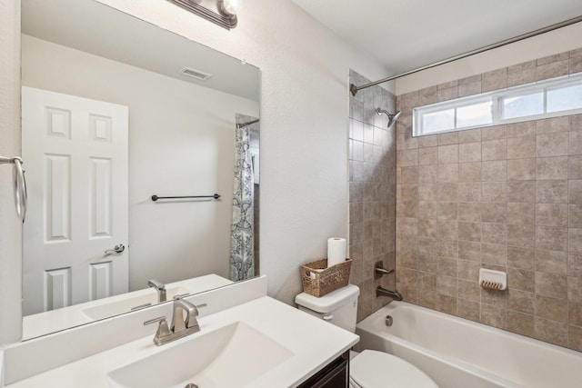 full bathroom featuring visible vents, shower / bath combo with shower curtain, toilet, and vanity