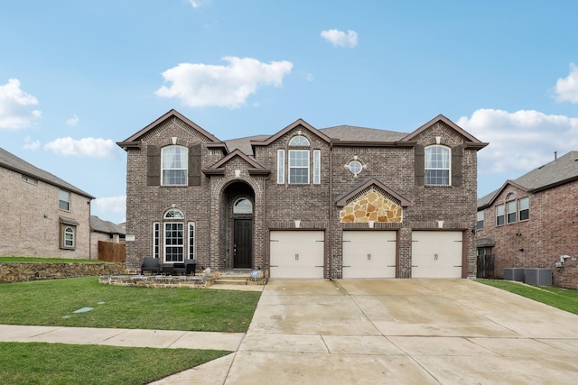 traditional-style home featuring concrete driveway, a garage, a front lawn, and brick siding