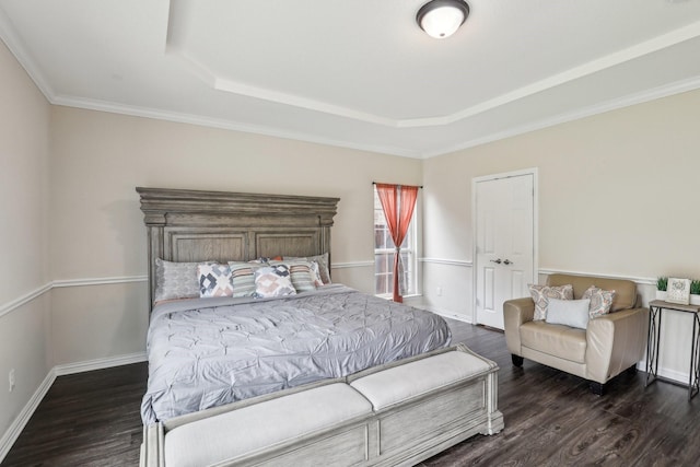bedroom with crown molding, dark wood-style flooring, a raised ceiling, and baseboards