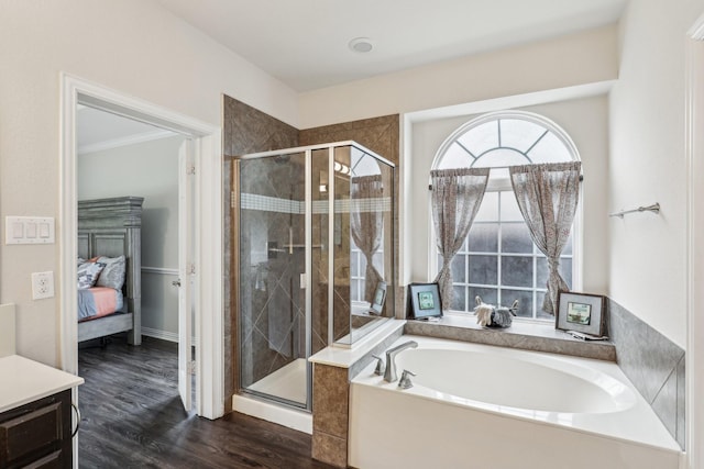 ensuite bathroom with wood finished floors, a garden tub, connected bathroom, and a stall shower
