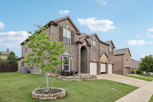 traditional home with a front lawn, brick siding, concrete driveway, an attached garage, and fence