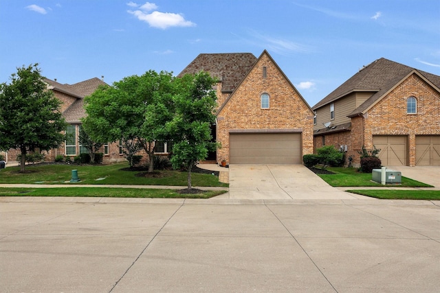 view of front of property featuring brick siding, a front lawn, an attached garage, and concrete driveway