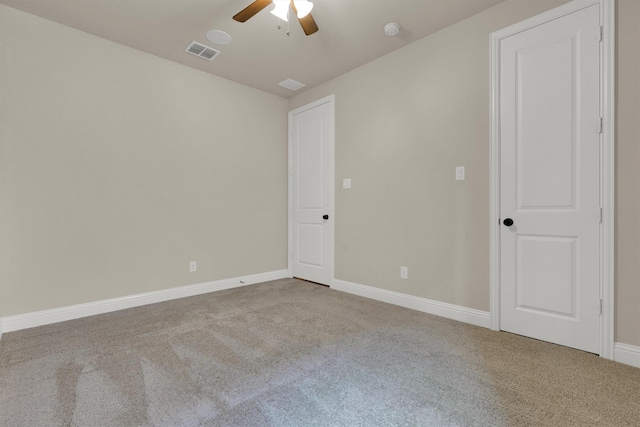 carpeted empty room with a ceiling fan, baseboards, and visible vents