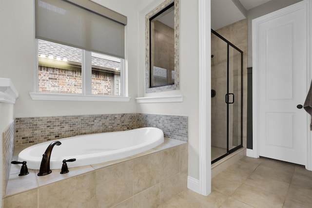 bathroom featuring tile patterned floors, a bath, and a shower stall