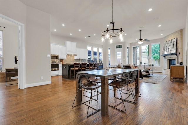 dining area with recessed lighting, dark wood-style flooring, ceiling fan with notable chandelier, and baseboards
