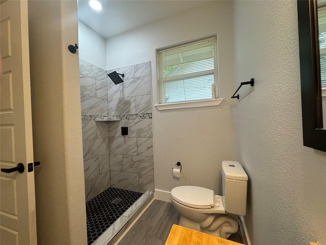 full bath featuring a walk in shower, toilet, and wood finished floors