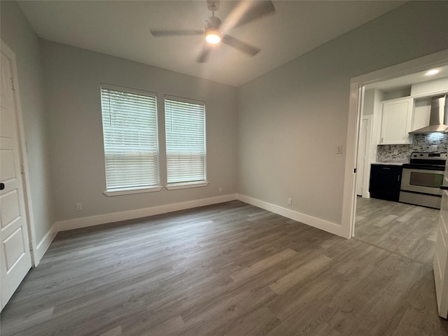 interior space featuring ceiling fan, wood finished floors, and baseboards