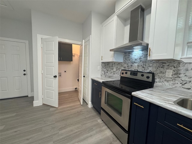 kitchen with electric stove, white cabinets, wall chimney range hood, and tasteful backsplash