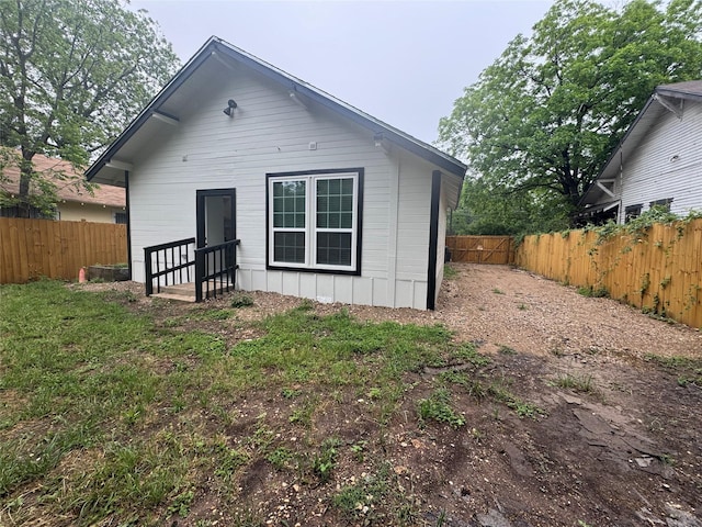 rear view of property with board and batten siding and a fenced backyard