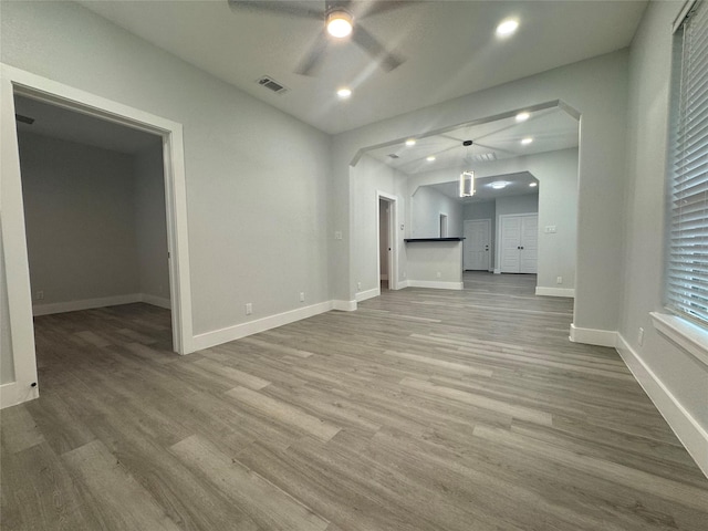 unfurnished living room with recessed lighting, wood finished floors, ceiling fan, baseboards, and visible vents