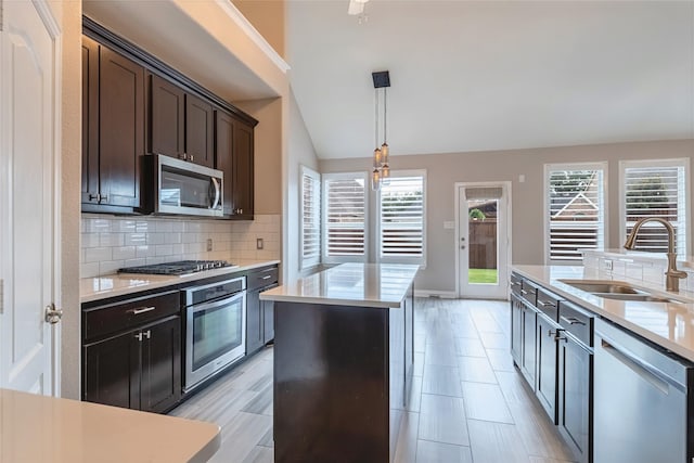 7955 Rasor Dr, Frisco, TX 75036 - kitchen with appliances with stainless steel finishes, a sink, a kitchen island, plenty of natural light, and vaulted ceiling
