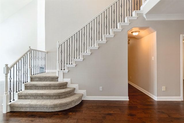 7955 Rasor Dr, Frisco, TX 75036 - staircase with hardwood / wood-style flooring, baseboards, a high ceiling, crown molding, and arched walkways