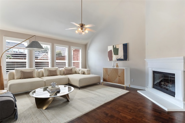 7955 Rasor Dr, Frisco, TX 75036 - living room with dark wood-style floors, a ceiling fan, lofted ceiling, baseboards, and a glass covered fireplace