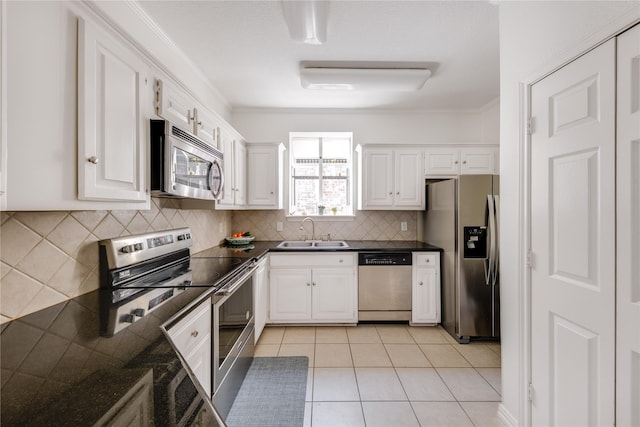 kitchen with tasteful backsplash, a sink, appliances with stainless steel finishes, and white cabinetry