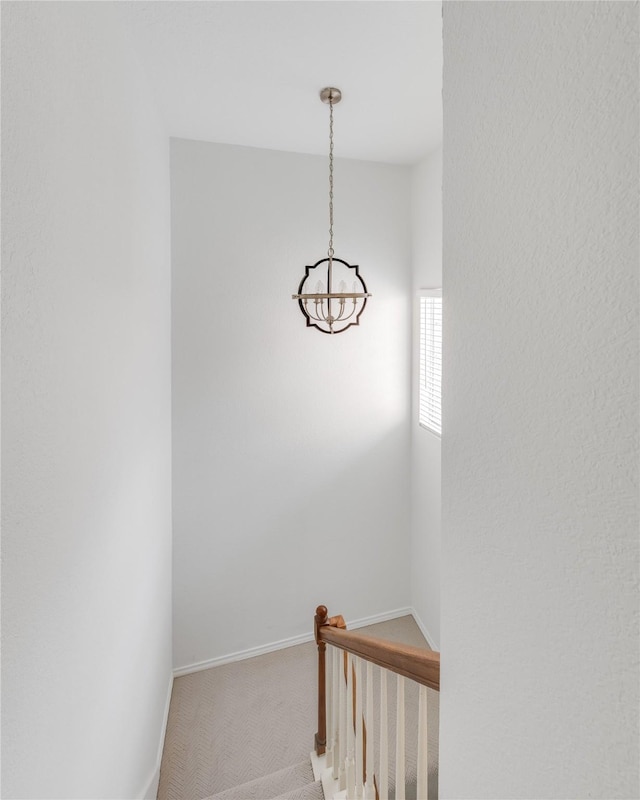 stairs with baseboards, a notable chandelier, and carpet flooring