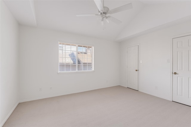 empty room featuring lofted ceiling, ceiling fan, light colored carpet, and baseboards