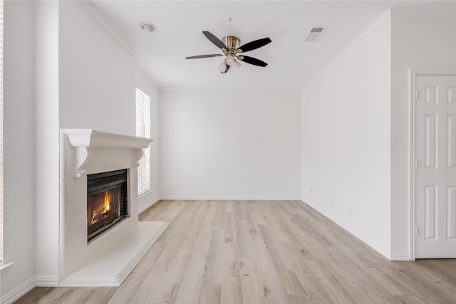 unfurnished living room with visible vents, wood finished floors, a ceiling fan, and crown molding