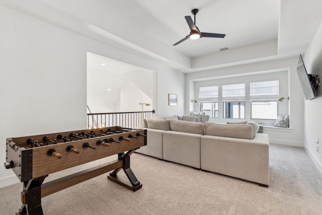 game room with ceiling fan, carpet floors, a tray ceiling, and visible vents