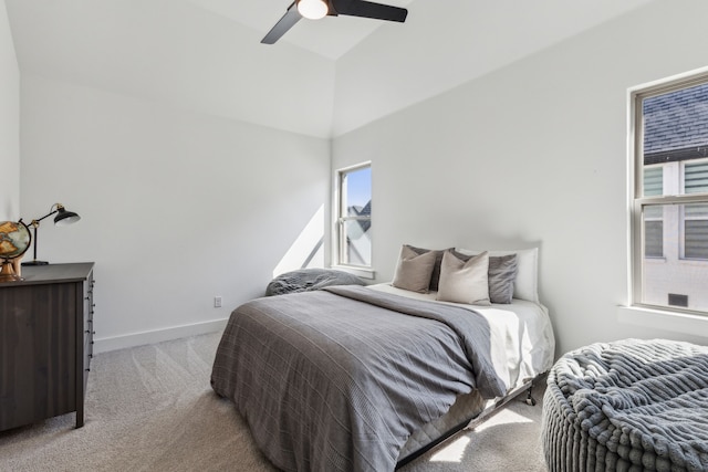bedroom with a ceiling fan, high vaulted ceiling, light carpet, and baseboards