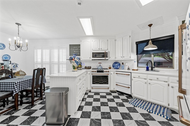 kitchen with a healthy amount of sunlight, white cabinets, white appliances, and a peninsula
