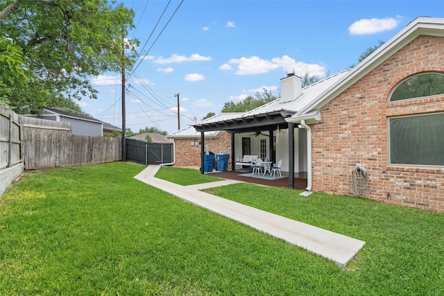 view of yard featuring a patio, ceiling fan, and a fenced backyard