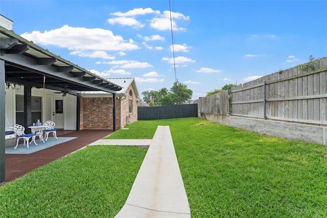 view of yard featuring ceiling fan, a patio area, and a fenced backyard