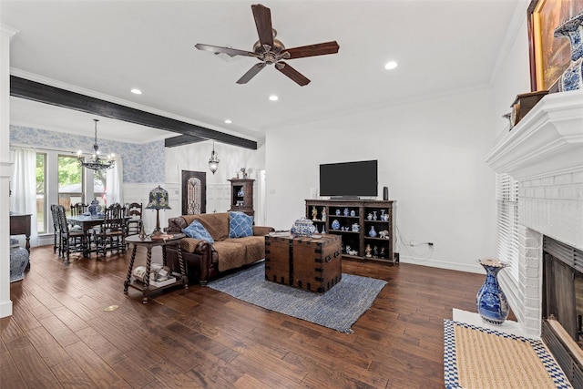 living room with a fireplace, wood finished floors, ornamental molding, and ceiling fan with notable chandelier