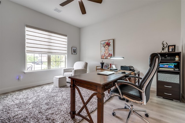 office space with a ceiling fan, visible vents, light wood-style floors, and baseboards