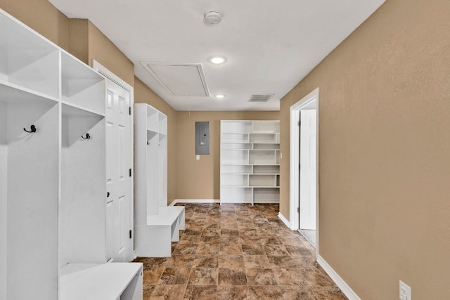 mudroom with attic access, electric panel, visible vents, stone finish floor, and baseboards