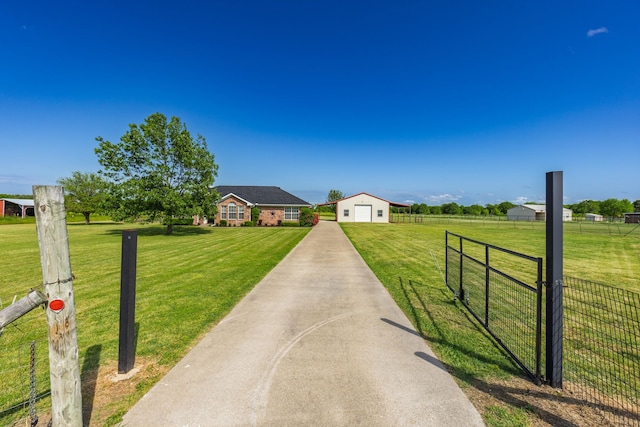 view of front facade featuring driveway, an outdoor structure, a detached garage, fence, and a front lawn