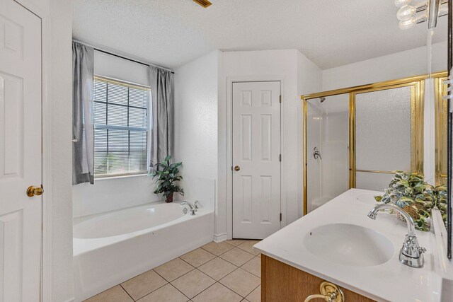 full bathroom with a garden tub, tile patterned flooring, double vanity, a sink, and a textured ceiling