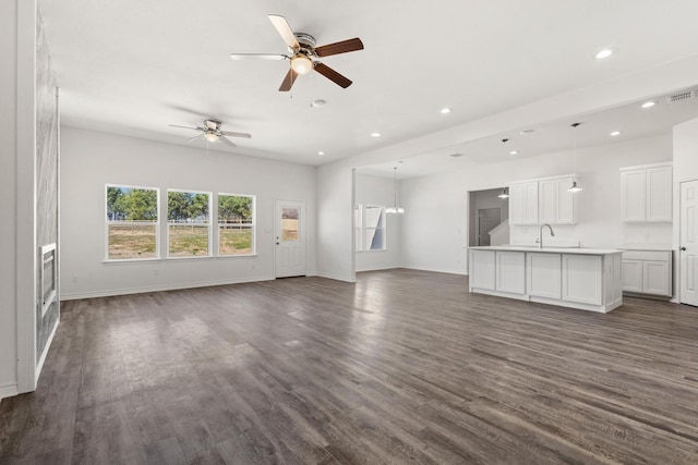 unfurnished living room with baseboards, recessed lighting, ceiling fan, and dark wood-type flooring