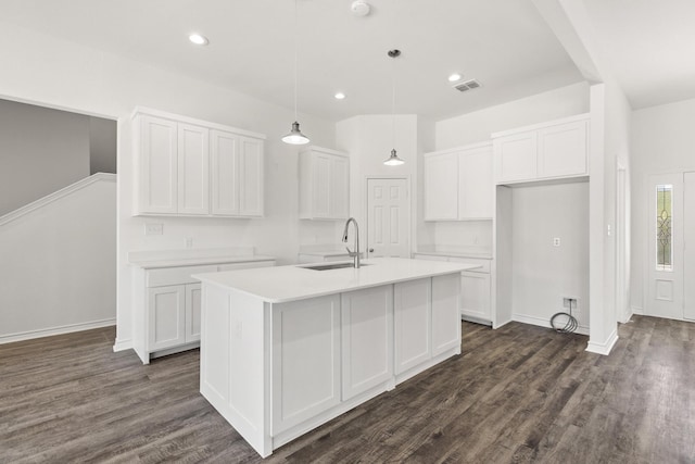 kitchen featuring white cabinetry, a center island with sink, dark wood-style floors, and a sink