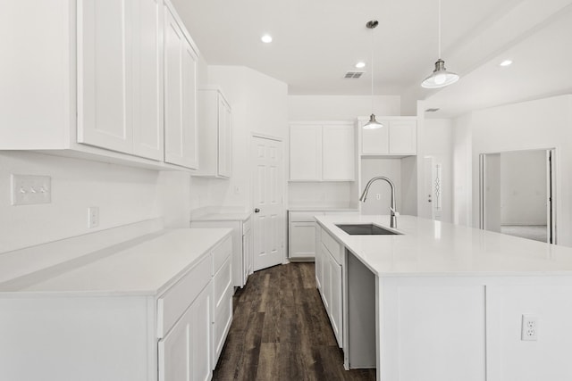 kitchen featuring dark wood-style flooring, a sink, visible vents, white cabinetry, and light countertops