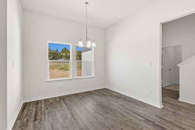 unfurnished dining area with a chandelier, dark wood-style floors, and baseboards
